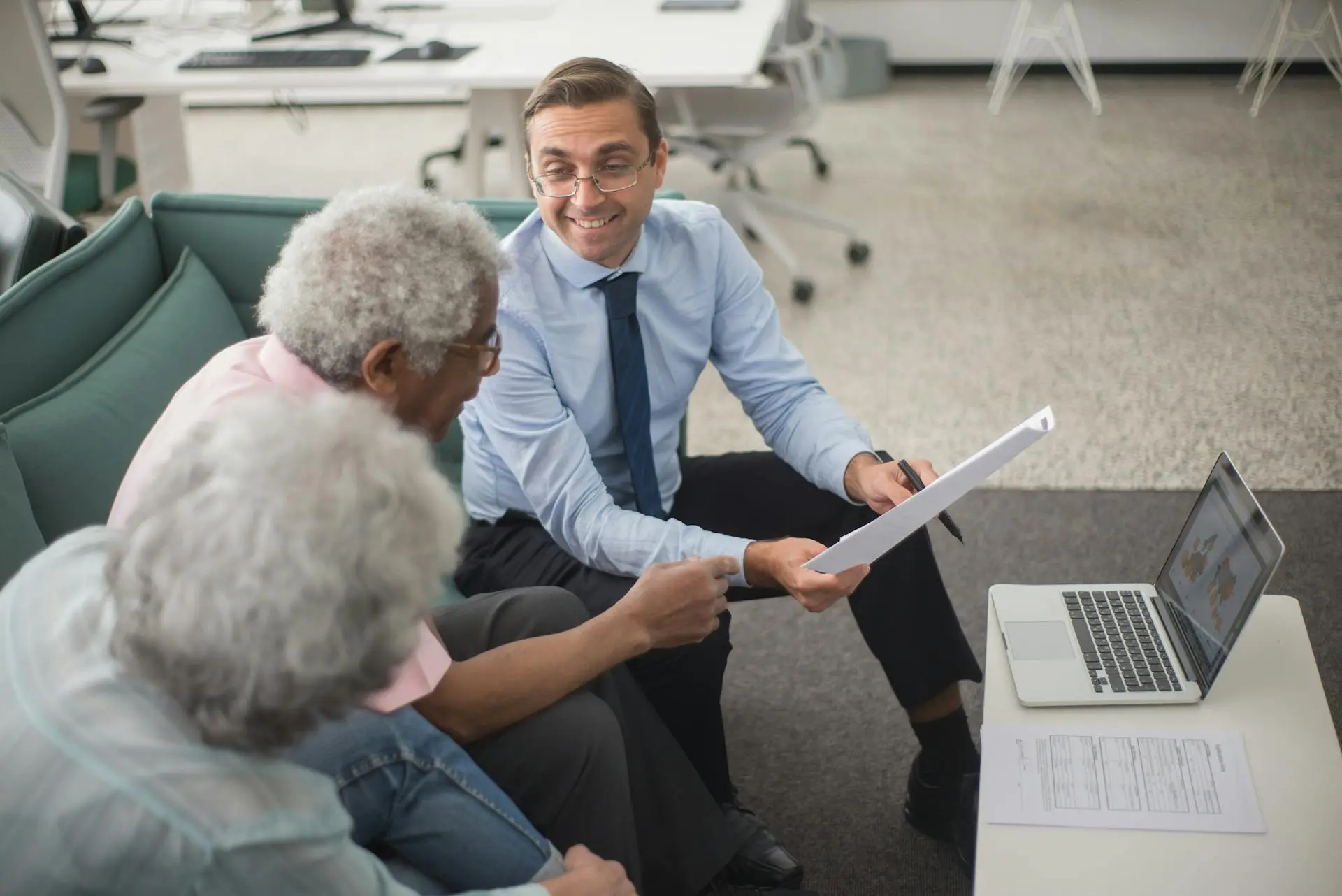 Professional lawyer consulting with senior client about problem tenant legal documentation in UK office