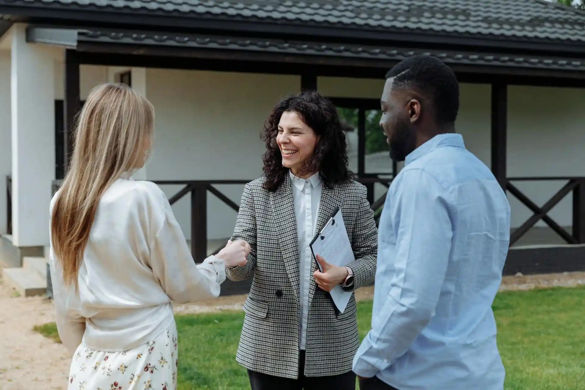 Professional property lawyer explaining guarantor benefits to young couple outside UK rental property